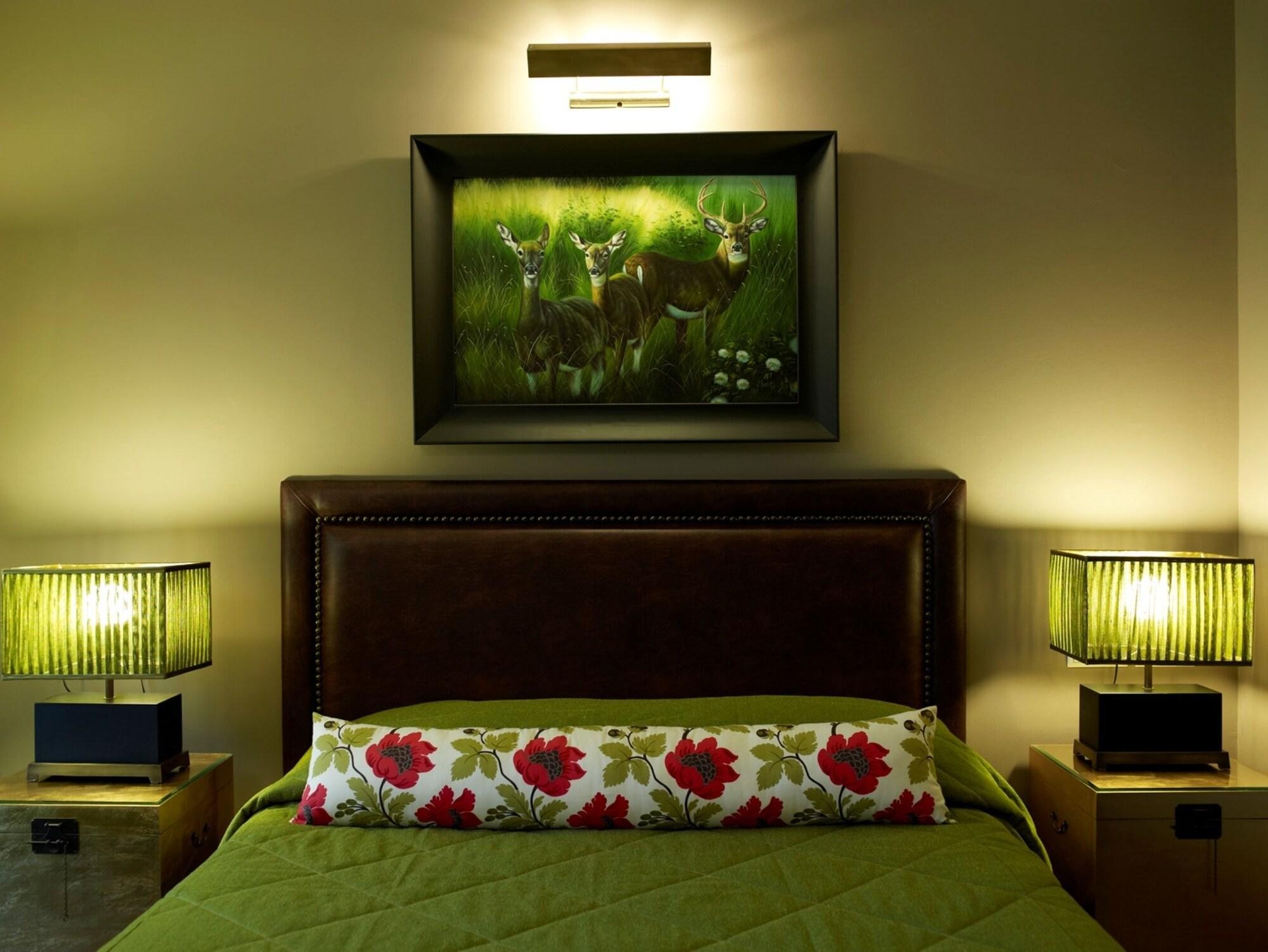 Hotel Du Lac Congress Center & Spa อิโออันนินา ภายนอก รูปภาพ A bedroom with a bed, a painting, and two bedside lamps