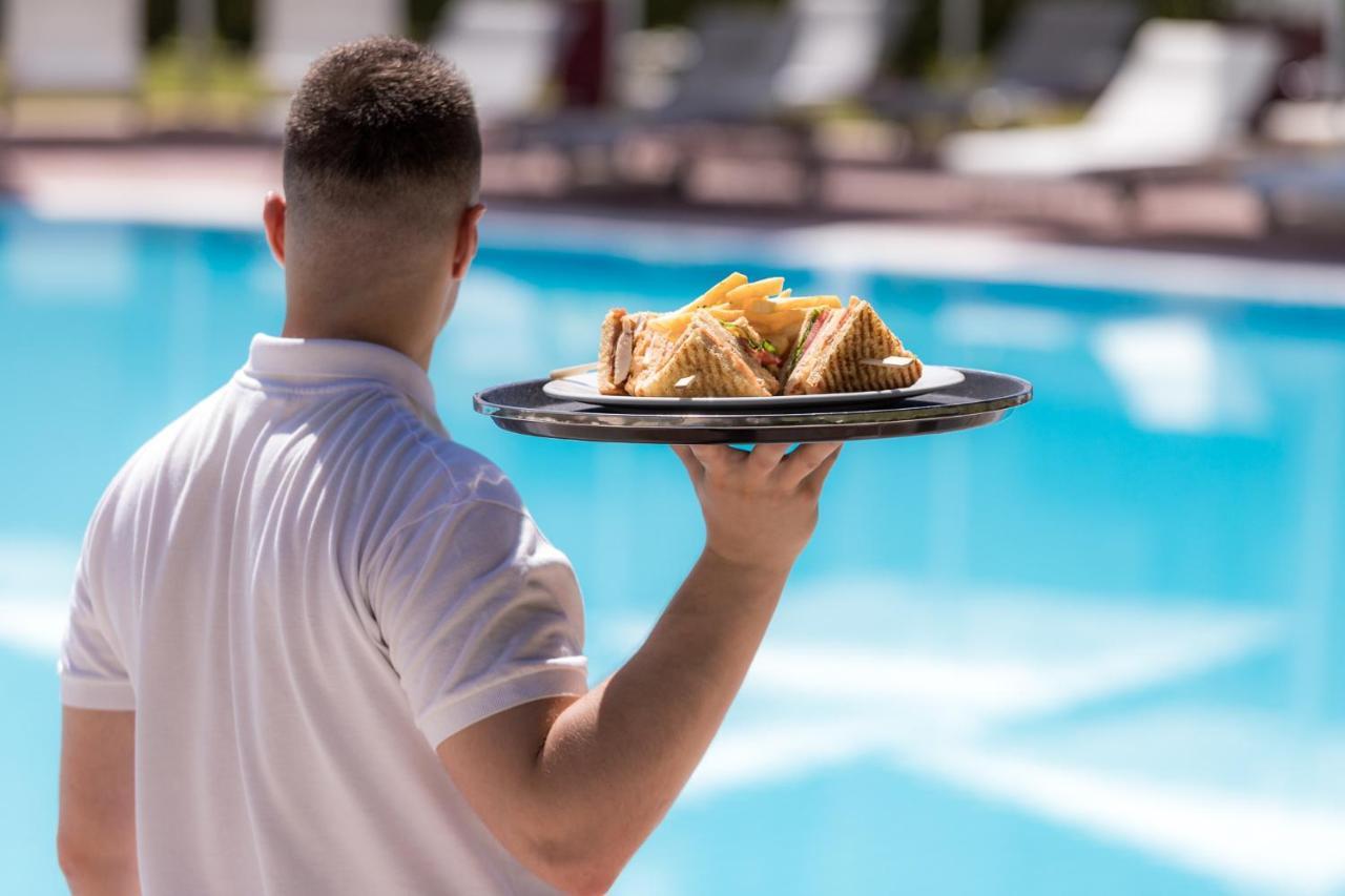 Hotel Du Lac Congress Center & Spa อิโออันนินา ภายนอก รูปภาพ A waiter serving food